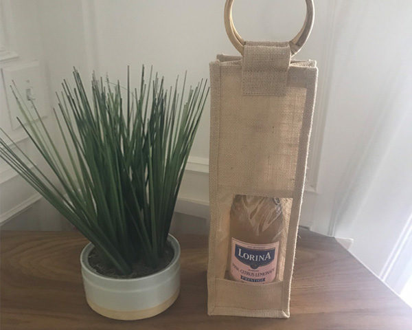 A bottle bag with bottle beside an indoor plant